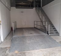Lagerhäuser und Hallen mit einer Metallplattform und Treppe, weiße Wände, industrieller Look.