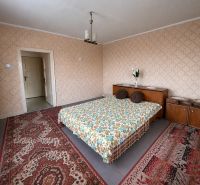 Schlafzimmer mit gemusterten Teppichen und einem Bett in einem Einfamilienhaus mit Holzelementen.