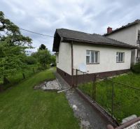 Ein Einfamilienhaus in Žilina mit gepflegtem Garten und Zaun, umgeben von Natur.