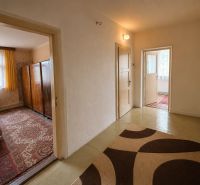 Der Flur in einem Einfamilienhaus mit Zugang zu den Zimmern und einem Teppichboden.
