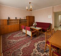 Wohnzimmer in einem Einfamilienhaus mit Holzdekor, Retro-Möbeln und einem orientalischen Teppich.