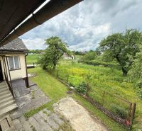 Ein Einfamilienhaus in Žilina, ein grüner Garten umgeben von Bäumen und ein ländlicher Zaun.