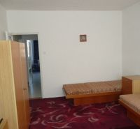 Ein Zimmer in einer 2-Zimmer-Wohnung mit einfacher Einrichtung und rotem Teppich.