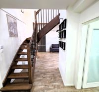 Eine Treppe mit einem Boden in Holzoptik in einer 3-Zimmer-Wohnung, ergänzt durch ein Kunstwerk an der Wand.