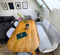 Esstisch mit Sofa und Pflanzen in einer 3-Zimmer-Wohnung, Boden mit Holzdekor.
