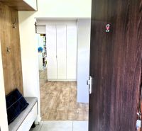 Eingangsbereich einer 3-Zimmer-Wohnung mit Holzboden und Sitzgelegenheit.