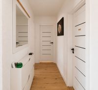 Ein heller Flur in einer 2-Zimmer-Wohnung mit weißen Türen und einem Boden in Holzoptik.