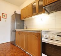 Küche in einer 2-Zimmer-Wohnung mit Holzboden und weißen Fliesen.