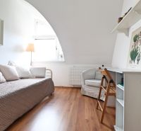 Ein Zimmer in einer 2-Zimmer-Wohnung mit einem Holzboden, einem Bett und einem Schreibtisch.
