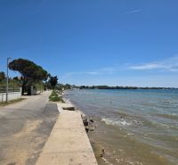 Die Küstenstraße in Privlaka verläuft bei sonnigem Wetter am Meer entlang.