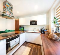 Küche in einer 3-Zimmer-Wohnung mit Holzboden, Zimmerpflanzen und modernen Geräten.