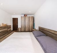 Schlafzimmer in einer 3-Zimmer-Wohnung mit Holzmöbeln und einem Boden in Holzoptik.