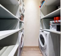 Stauraum mit Regalen und Waschmaschine in einer 3-Zimmer-Wohnung mit Holzboden.