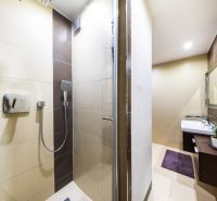 Badezimmer mit Dusche, helle Fliesen und Waschbecken, 3-Zimmer-Wohnung.