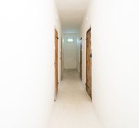 Der Flur in einer 3-Zimmer-Wohnung mit weißen Wänden und Türen zu den Räumen.