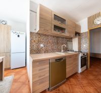 Küche in einer 3-Zimmer-Wohnung mit Holzboden und Keramikfliesen.
