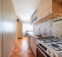 Küche in einer 3-Zimmer-Wohnung mit Küchenzeile und Fliesen in Steinoptik.