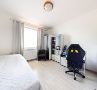Helles Zimmer in einer 3-Zimmer-Wohnung mit Holzboden und Schreibtisch.