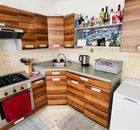 Küche in einer Einzimmerwohnung mit Holzelementen und eingebautem Herd.