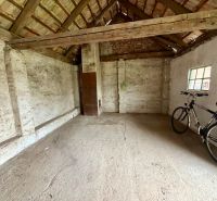 Ein geräumiges Zimmer in einem Einfamilienhaus mit einem Fahrrad und einer Holzdecke.