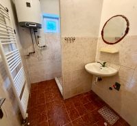 Badezimmer in einem Einfamilienhaus mit gefliestem Boden und Waschbecken.