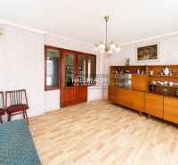 Wohnzimmer in einem Einfamilienhaus mit Retro-Möbeln und einem Boden in Holzoptik.