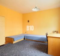 Ein Zimmer in einem Einfamilienhaus mit blauen Betten, einem Schreibtisch und einem Teppich.
