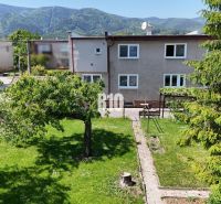 Ein Einfamilienhaus in Martin mit einem weitläufigen Garten und Bergen im Hintergrund.