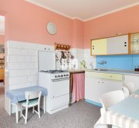 Küche in einem Einfamilienhaus mit Retro-Möbeln, bunte Schränke, Esstisch.
