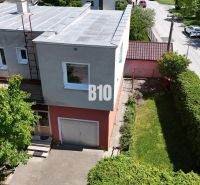 Ein Einfamilienhaus in Martin mit Garten, Garage und Bäumen vor dem Gebäude.