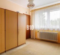 Ein Zimmer in einem Einfamilienhaus mit einem Schrank, Vorhängen und einem Heizkörper.