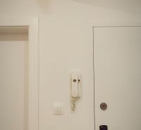 Weißes Interieur mit einem elektrischen Verteilerkasten und einem Haustelefon in einer 4-Zimmer-Wohnung.
