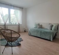 Ein Zimmer in einer 4-Zimmer-Wohnung mit einem Boden in Holzoptik und hellen Möbeln.