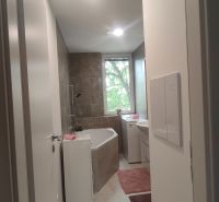 Badezimmer mit Dusche und Badewanne in einer 4-Zimmer-Wohnung, helle Fliesen und Bodenbeläge.