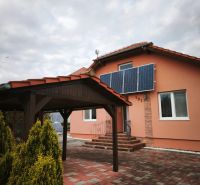 Ein Einfamilienhaus in Martin nad Žitavou mit Solarpaneelen und einem Pavillon auf der Terrasse.