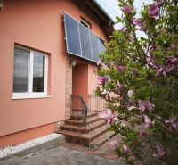 Ein Einfamilienhaus in der Hauptstraße in Martin nad Žitavou mit Solarpaneelen und einer Magnolie.