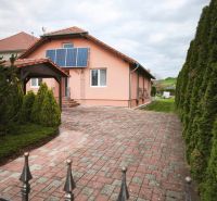 Ein Einfamilienhaus in Martin nad Žitavou in der Hauptstraße mit Solarpaneelen und gepflastertem Hof.