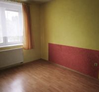 Ein Zimmer in einem Einfamilienhaus mit einem Holzboden und einer farbigen Wand.