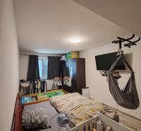 Ein Kinderzimmer in einer 3-Zimmer-Wohnung mit einem Bett und einem Fernseher an der Wand.