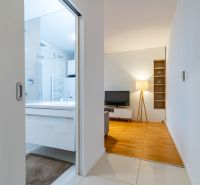 Eingang zum Badezimmer und Wohnzimmer mit Holzboden in einer 2-Zimmer-Wohnung.