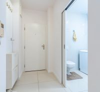 Flur in einer 2-Zimmer-Wohnung mit Gegensprechanlage, Schrank und eingebautem WC mit hellen Fliesen.