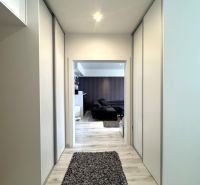 Flur mit Einbauschränken und Boden in Holzoptik in einer 4-Zimmer-Wohnung.