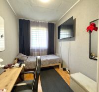 Ein Zimmer in einer 4-Zimmer-Wohnung mit einem Schreibtisch, einem Bett und einem Fernseher an der Wand.