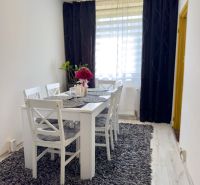 Esszimmer mit grauem Teppich und weißen Möbeln in einer 4-Zimmer-Wohnung.