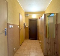 Ein Flur mit Schränken in einer 4-Zimmer-Wohnung mit Fliesenboden und Holztüren.
