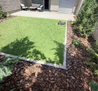 Der Garten einer 2-Zimmer-Wohnung in Galanta mit Rasenfläche und Terrassensitzbereich.