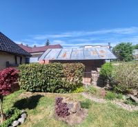 Ein Einfamilienhaus in der Hauptstraße in Banské mit einem gepflegten Garten und blauem Himmel.