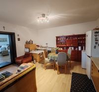 Wohnzimmer in einem Einfamilienhaus mit Holzboden und Kochnische.