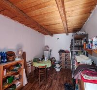 Ein Zimmer in einem Einfamilienhaus mit einem Boden in Holzoptik und Aufbewahrungsregalen.