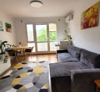 Wohnzimmer mit Sofa in einer 3-Zimmer-Wohnung mit Holzboden und Dekorationen.